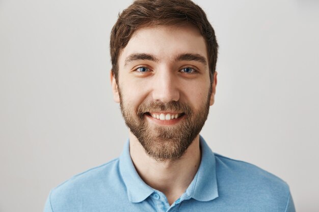 Bärtiges Porträt eines jungen Mannes mit blauem T-Shirt