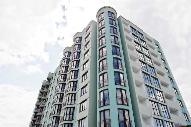 Balkon eines neuen, modernen, türkisfarbenen, mehrstöckigen Wohnhauses in einem Wohngebiet am sonnigen blauen Himmel