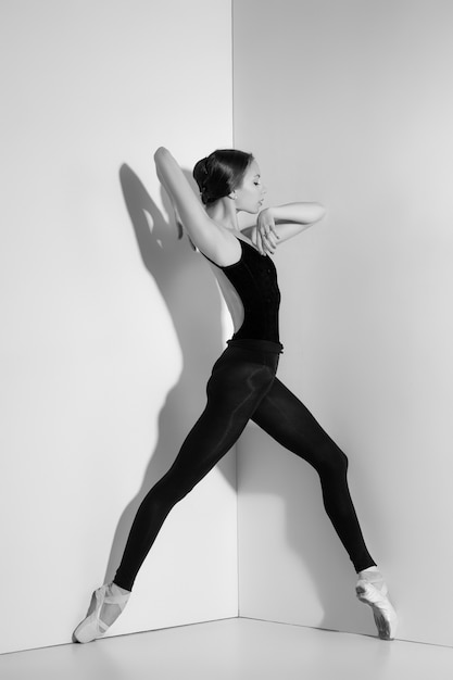 Ballerina im schwarzen Outfit posiert auf Spitzenschuhen