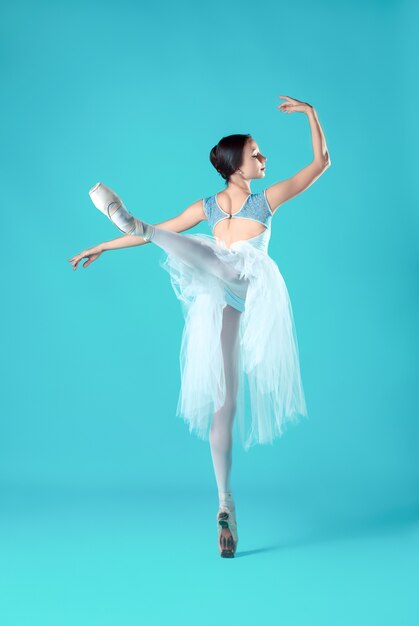 Ballerina im weißen Kleid, das auf Zehen aufwirft