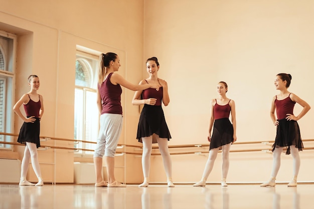 Ballettlehrer, der eine Klasse für eine Gruppe von Ballerinas abhält und mit ihnen im Tanzstudio kommuniziert