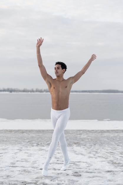 Kostenloses Foto balletttänzer, der elegante haltung auf straße durchführt