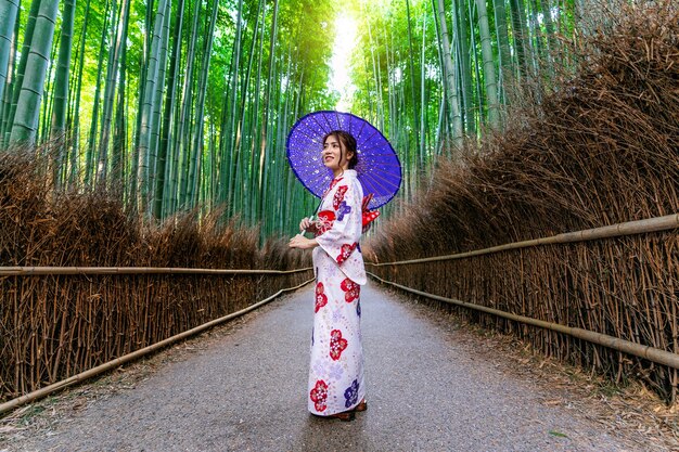 Bambuswald. Asiatische Frau, die traditionellen japanischen Kimono am Bambuswald in Kyoto, Japan trägt.