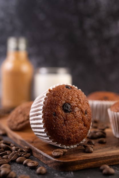 Bananen-Cupcakes, die auf einen Holzteller mit Kaffeekörnern gelegt werden.