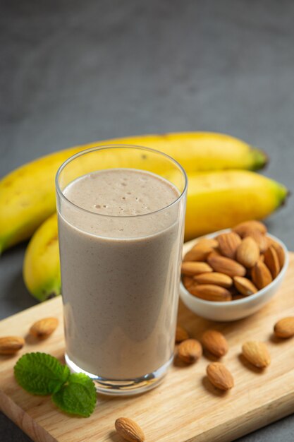 Bananen-Mandel-Smoothie auf dunklem Hintergrund