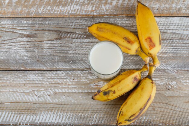 Bananen mit Milch auf Holz,