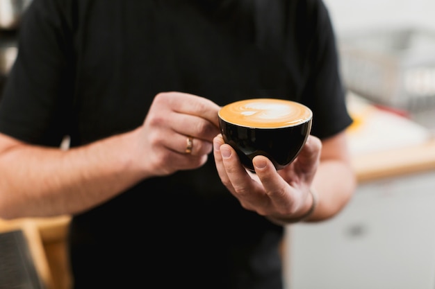 Bar-Konzept mit dem Kellner, der Kaffeetasse hält