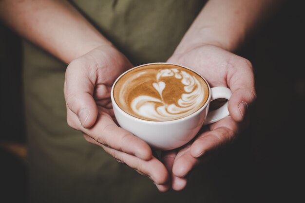 Barista, der Hot Cafe Latte behandelt.