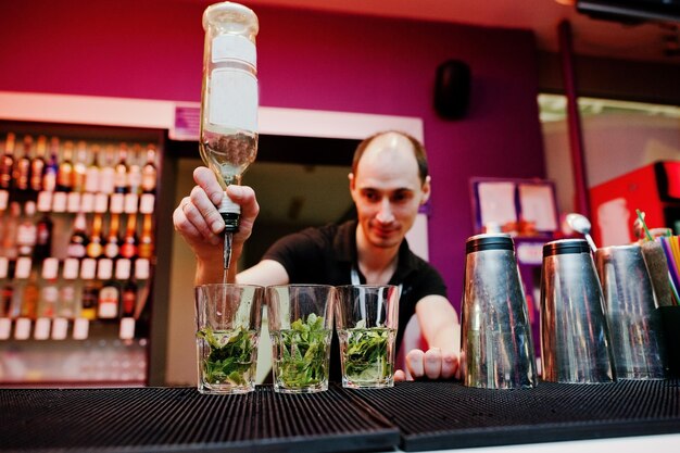 Barkeeper bereitet Mojito-Cocktailgetränk an der Bar zu