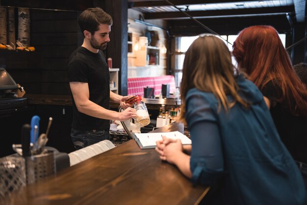 Barkeeper, der Bier an der Bartheke serviert