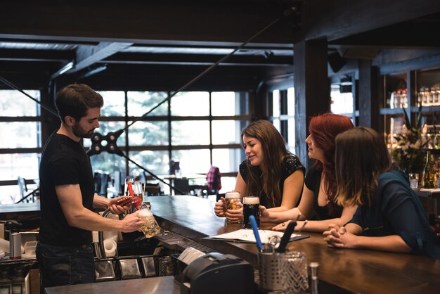 Barkeeper, der Bier an der Bartheke serviert