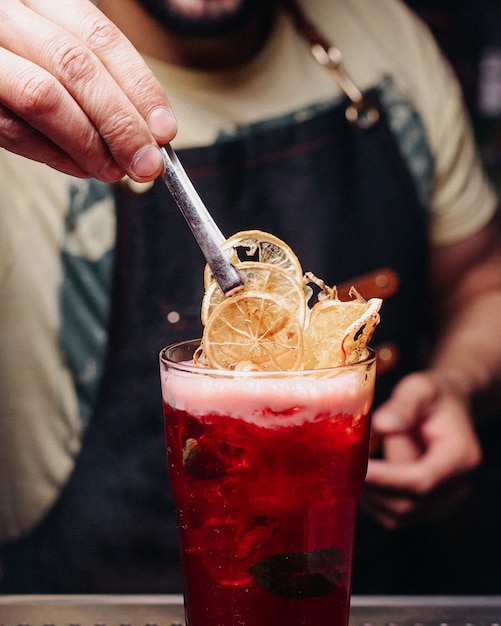 Barkeeper der Vorderansicht, der ein rotes Getränk vorbereitet