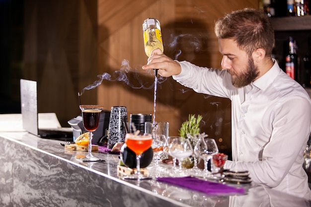 Barkeeper gießt Cocktailzutaten. Lounge-Atmosphäre