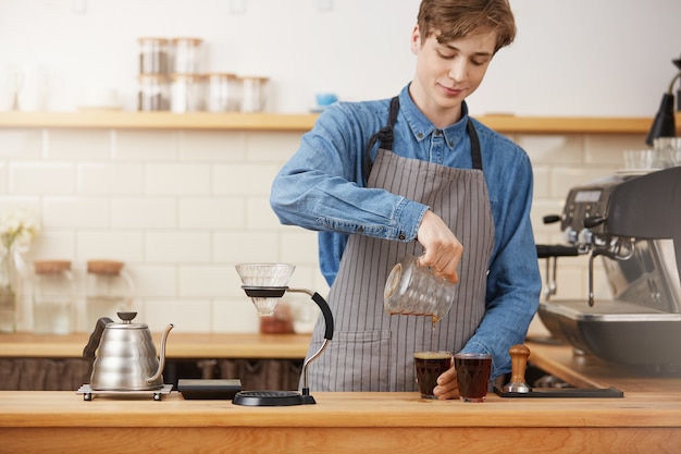 Barkeeper Hände gießen alternativen Kaffee in zwei Glasbecher