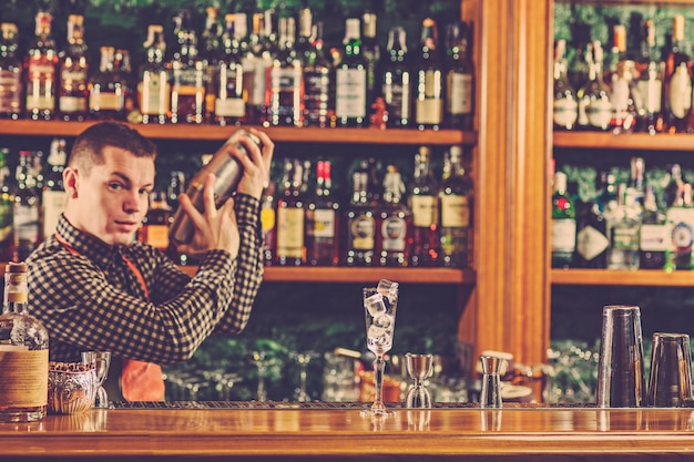 Barkeeper macht einen alkoholischen Cocktail an der Theke an der Bar