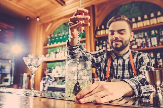 Barkeeper macht einen alkoholischen Cocktail an der Theke an der Bar