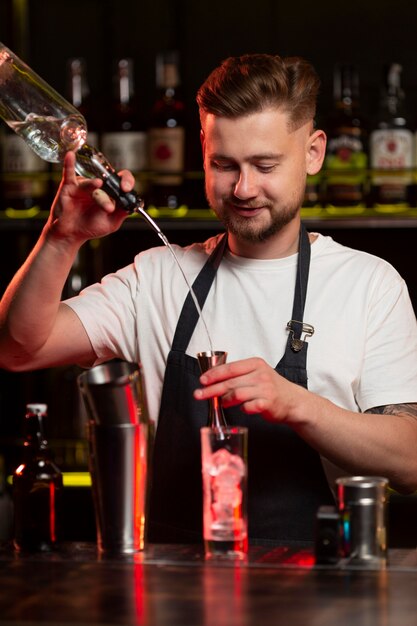 Barkeeper macht einen Cocktail mit einem Shaker
