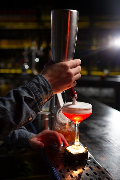 Barkeeper macht einen Cocktail mit einem Shaker