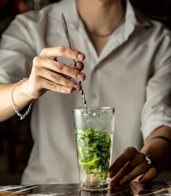Barkeeper mischt Mojito-Cocktail mit Metalllöffel