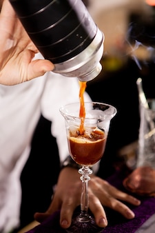 Barmann, der alkoholisches kaffeegetränk macht. gießen von getränk