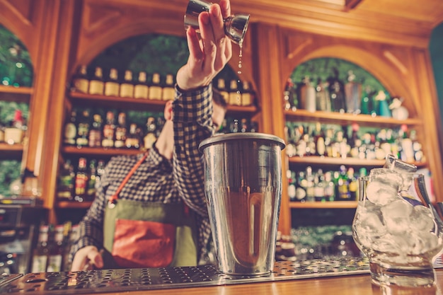 Barmann macht einen alkoholischen Cocktail an der Theke an der Bar