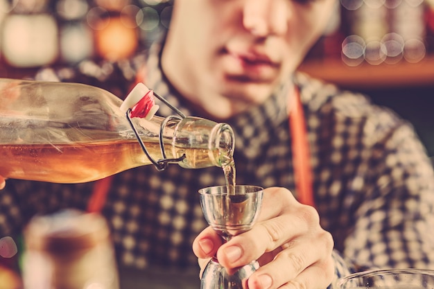 Barmann macht einen alkoholischen Cocktail an der Theke