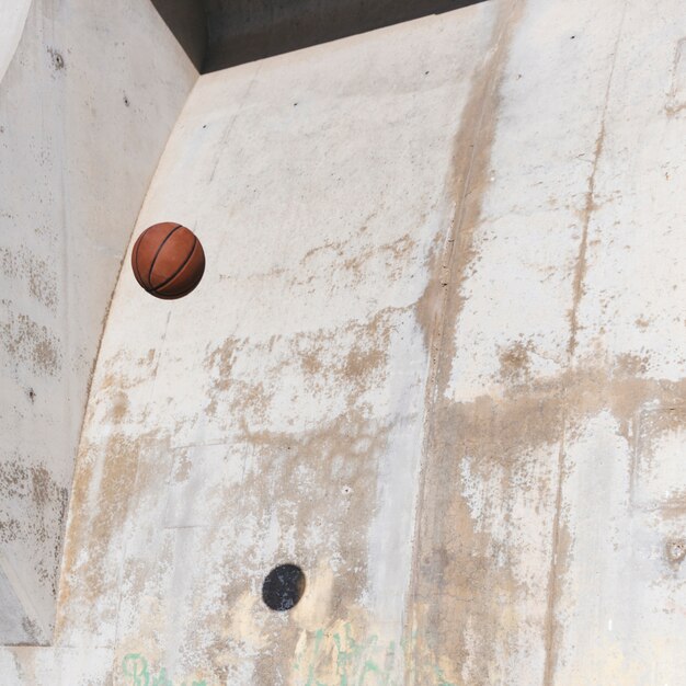 Basketball in der Luft gegen grunge Wand