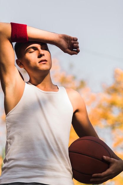 Kostenloses Foto basketball-spieler, der die sonne genießt