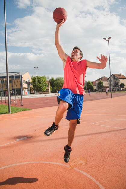 Basketballspieler auf Hof in urbana Umgebung