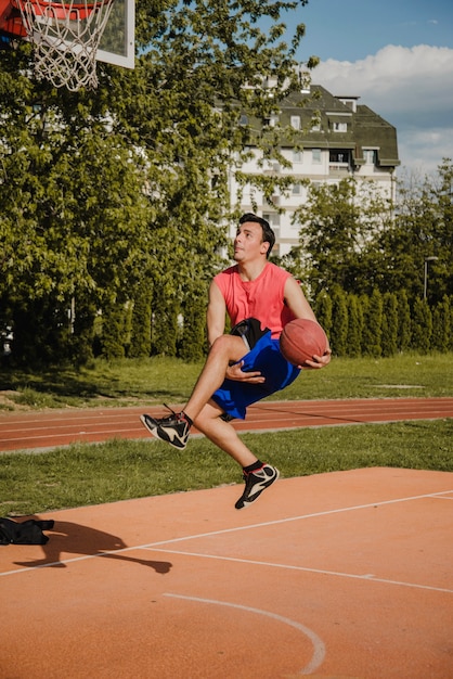 Kostenloses Foto basketballspieler, der trick springt