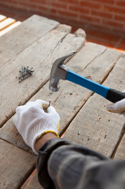 Bauarbeiter benutzt Hammer auf der Baustelle