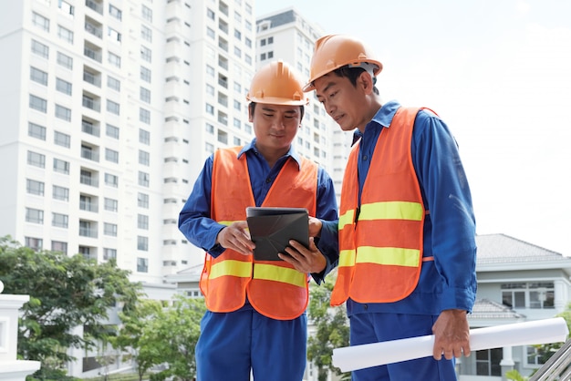 Bauingenieure, die Daten bezüglich der Tablette überprüfen