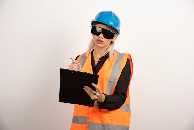 Baumeisterin der jungen Frau mit Schutzbrille und Zwischenablage. Hochwertiges Foto