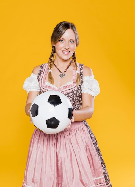 Kostenloses Foto bayerische junge frau, die fußball hält