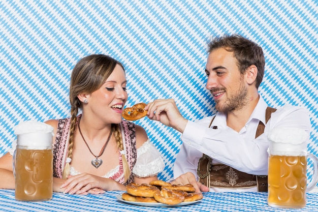 Bayerische Paare, die deutsche Brezel schmecken