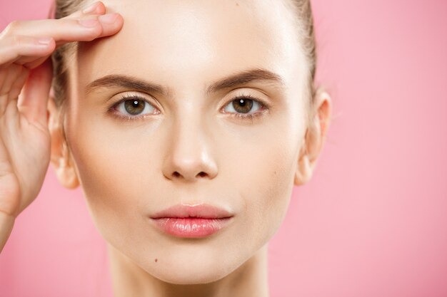 Beauty-Konzept - Close up Portrait von attraktiven kaukasischen Mädchen mit Schönheit natürlichen Haut isoliert auf rosa Hintergrund mit Kopie Raum.