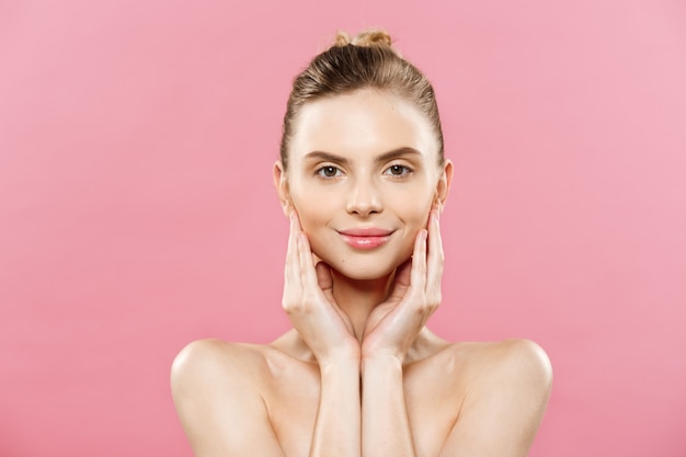 Beauty-Konzept - Schöne kaukasischen Frau mit sauberen Haut, natürliche Make-up isoliert auf helle rosa Hintergrund mit Kopie Raum.