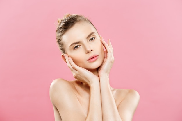 Beauty-Konzept - Schöne kaukasischen Frau mit sauberen Haut, natürliche Make-up isoliert auf helle rosa Hintergrund mit Kopie Raum.