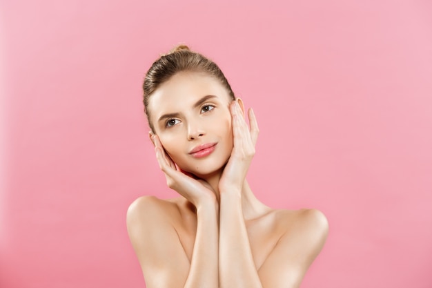 Beauty-Konzept - Schöne kaukasischen Frau mit sauberen Haut, natürliche Make-up isoliert auf helle rosa Hintergrund mit Kopie Raum.