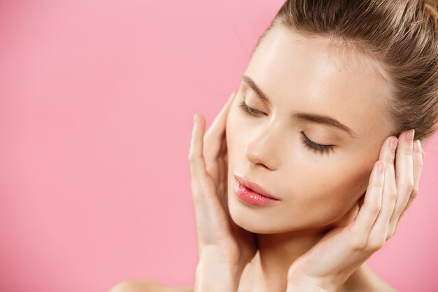 Beauty-Konzept - Schöne kaukasischen Frau mit sauberen Haut, natürliche Make-up isoliert auf helle rosa Hintergrund mit Kopie Raum.