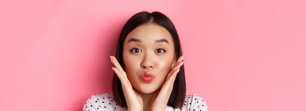 Beauty- und Lifestyle-Konzept Nahaufnahme einer entzückenden asiatischen Frau, die die Lippen im Kussständer berührt