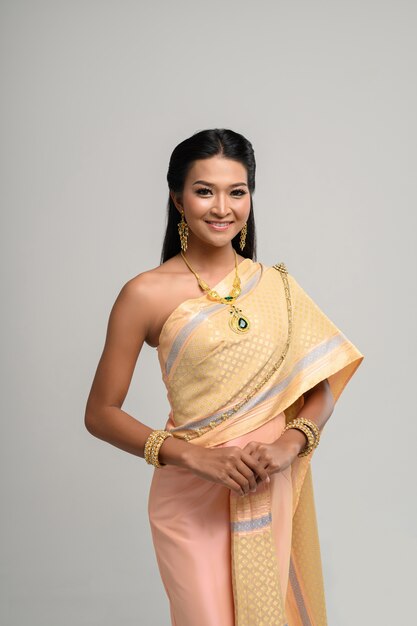 Beautyful thailändische Frau, die thailändisches Kleid und Lächeln trägt