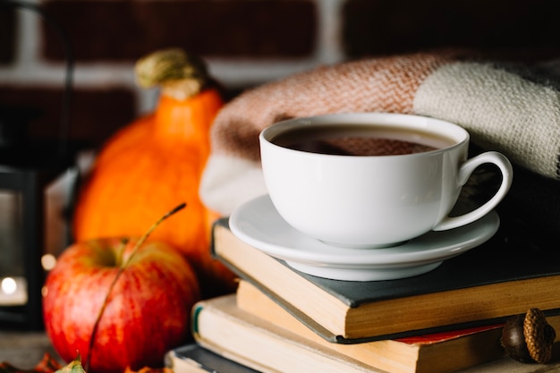 Becher auf Stapel von Büchern im Herbst