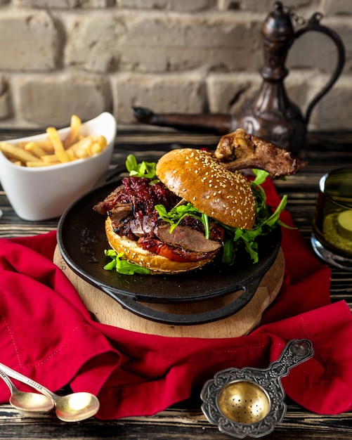 Beef burger in sesambrötchen serviert mit pommes