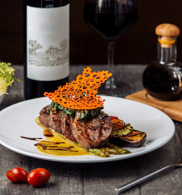 Beefsteakscheiben garniert mit Kräutern und Sauce, serviert mit gegrilltem Gemüse