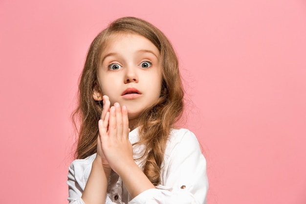 Beeindruckend. Schönes weibliches Frontporträt lokalisiert auf rosa Wand. Junges emotional überraschtes jugendlich Mädchen. Menschliche Emotionen, Gesichtsausdruckkonzept.