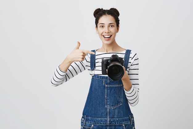 Beeindruckte Fotografin zeigt mit dem Finger auf die Kameraanzeige, lobt tolle Aufnahmen, tolle Modellarbeit