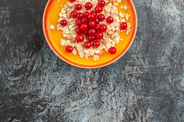 Beerenplatte der oberen Nahaufnahmeansicht der appetitlichen roten Johannisbeeren auf dem grauen Tisch