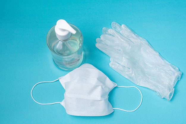 Behälter mit Alkoholgel, Handschuhen und OP-Maske