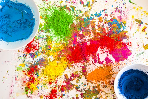 Behälter mit blauen Farben in der Nähe von Haufen von hellen, trockenen Farben